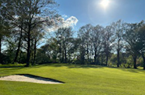 Green entouré d’arbres, typique du tracé naturel du Golf de Caden